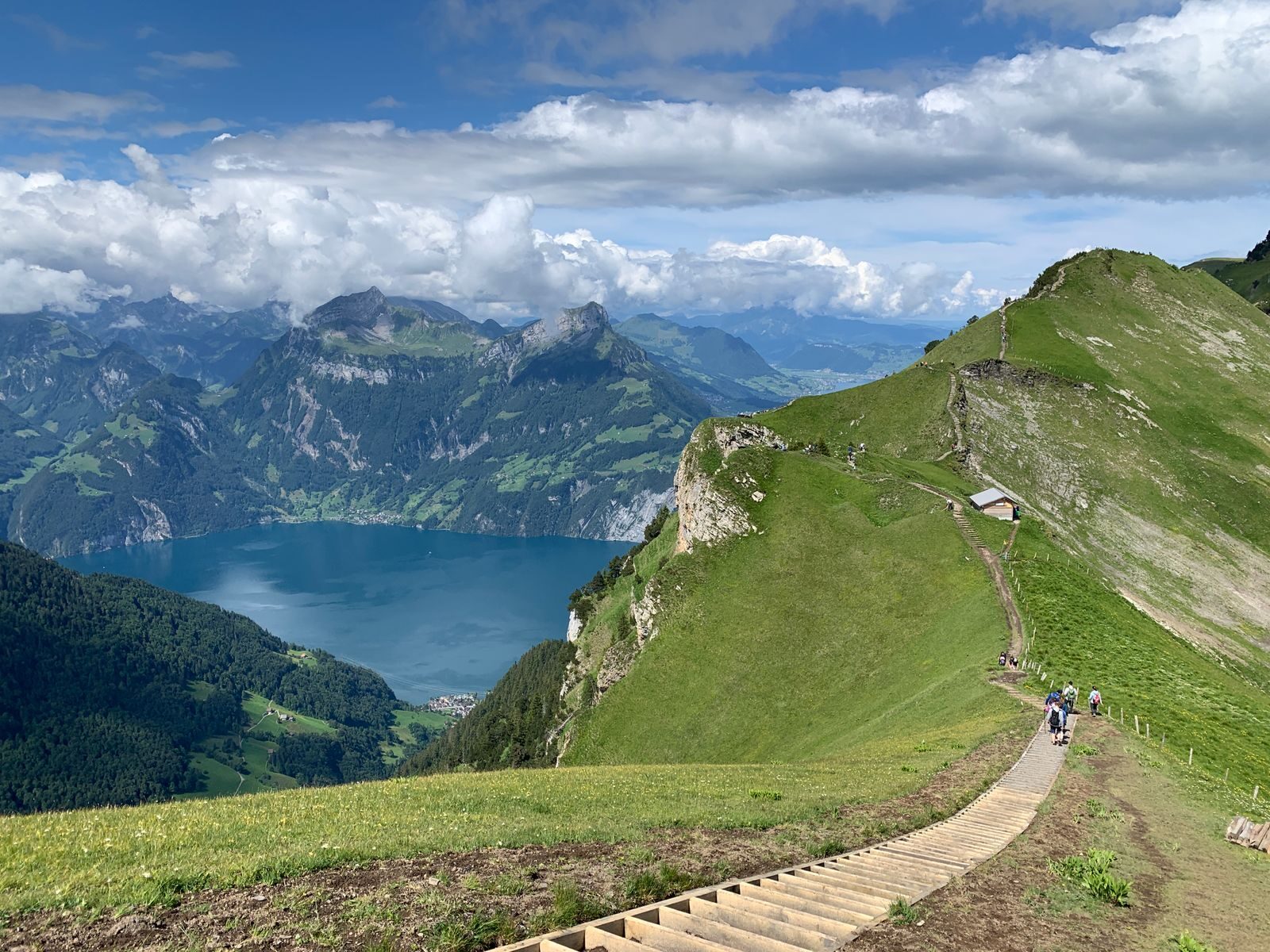 Breathtaking view of mountains, lake, and lush greenery in a scenic alpine landscape.